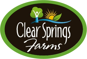 Clear Springs Farms logo featuring a tree, sun, and green leaves on a dark oval background.